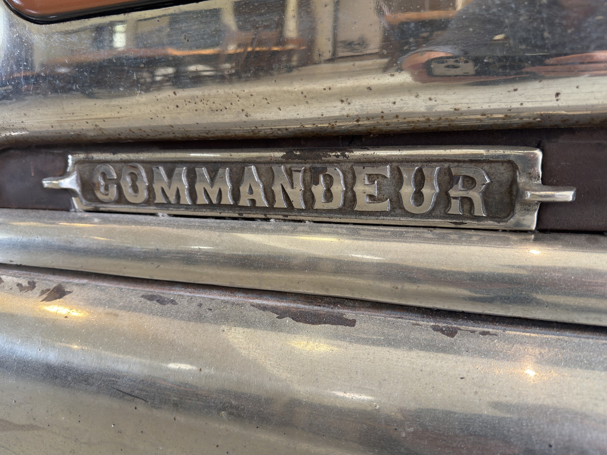 Gros plan de l’inscription Commandeur sur un poêle ancien.